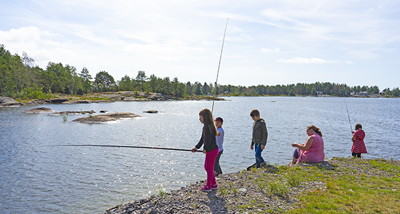 Barn som metar vid Vänerns strand.