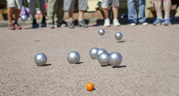 Bouleklot i spel. Massor av ben i bakgrunden i oskärpa. Sommardag.