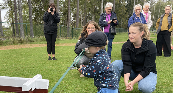 Ett förskolebarn klipper bandet för invigningen av hönshuset.